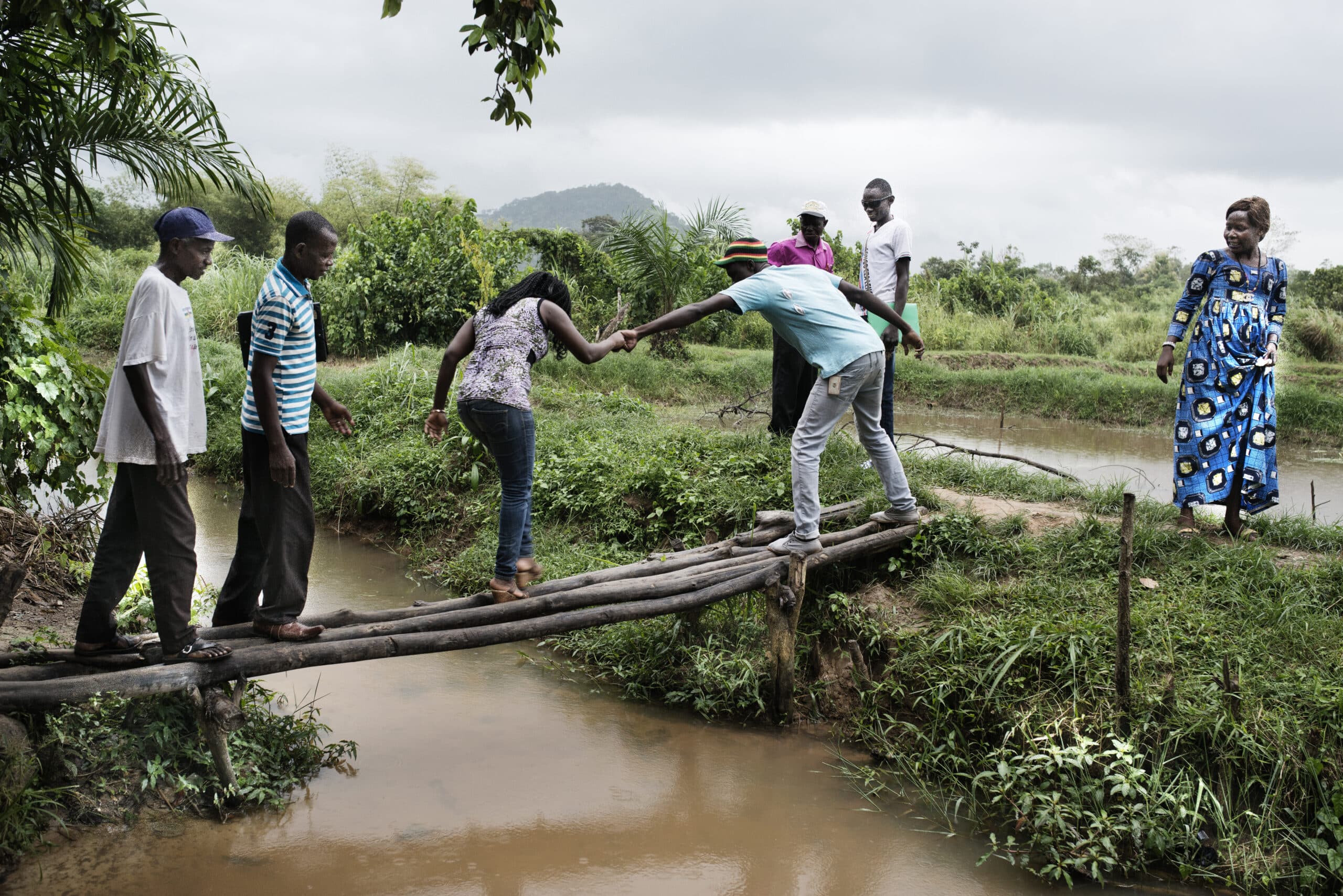 Des membres de la PIJCA (Plateforme interconfessionnelle de la jeunesse centrafricaine) traversent un bassin de pisciculture établi après leur dialogue avec les différentes communautés du PK 22 ©Michael ZUMSTEIN/CCFD-Terre Solidaire